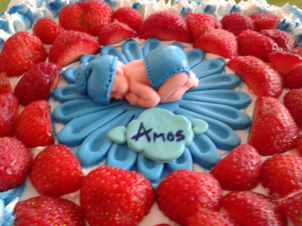 torta decorata con panna con topper neonato in pasta di zucchero